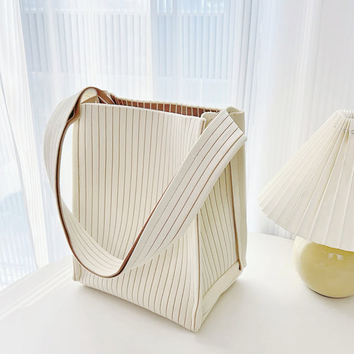 Close-up of Cream woven tote bag with vertical texture, milk carton design, and brown striped lining.