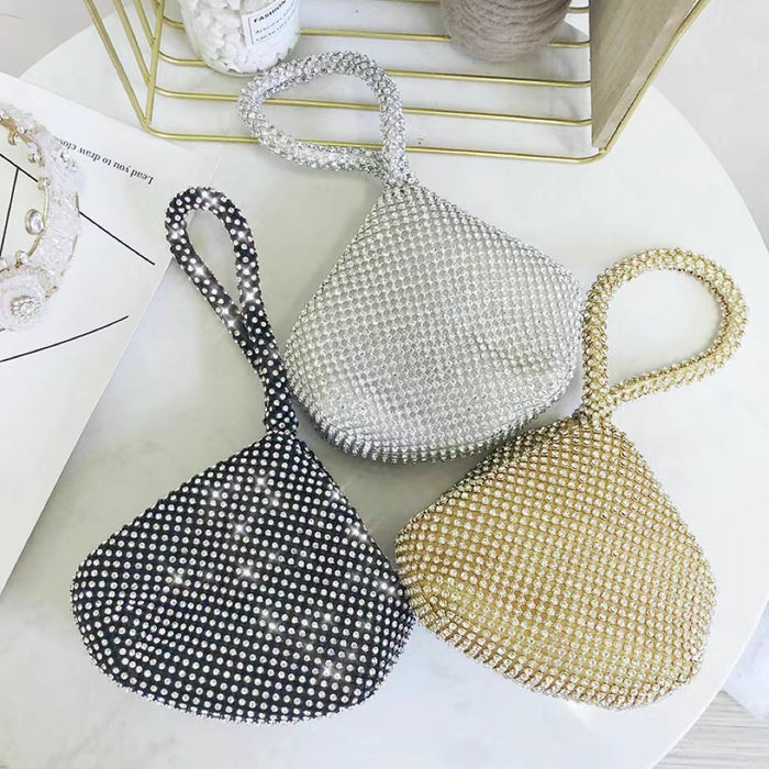 Front view of Three mini diamond party handbags: black, silver, and gold rhinestone, with a top handle.