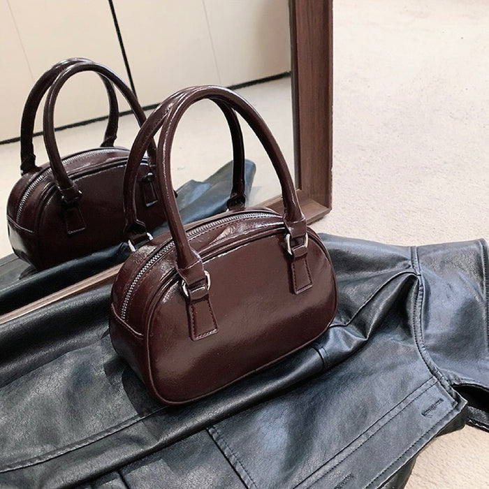 Close-up of unber PU leather bowling bag with grab handle and zip-top,.