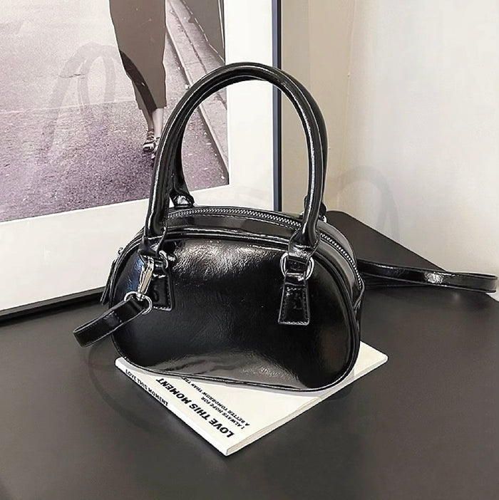 Folded view of Mini Leather Bowling Bag in black, easy for commuting and weekends.