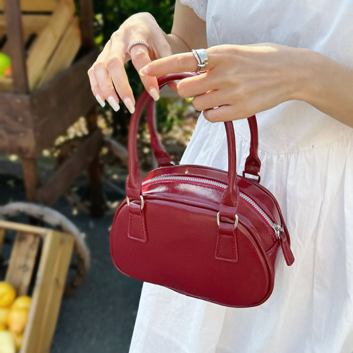 Model carrying a red bag handheld, ideal for city walks and gifting.