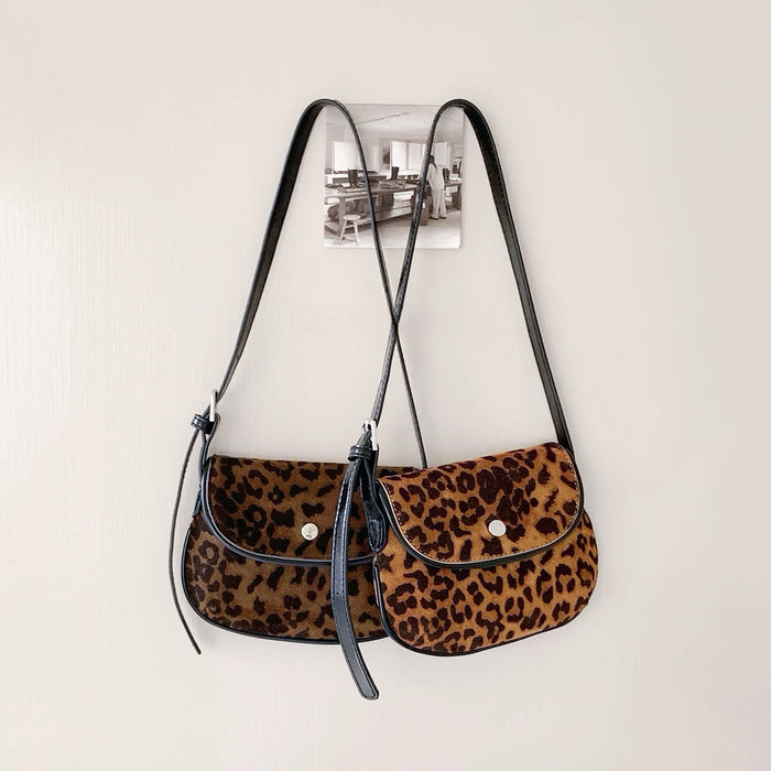 Two mini leopard print vegan suede saddle bags with black straps and magnetic flap closures. great for everyday carry.