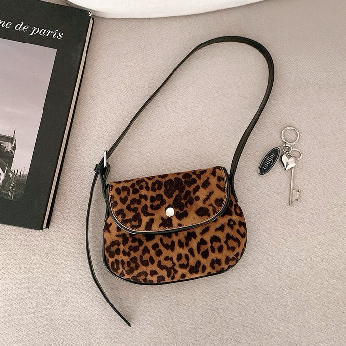 Flat lay of Mini Leopard Suede Saddle Bag, great for everyday carry and travel.