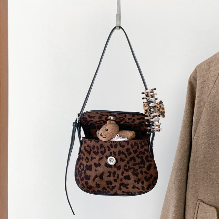 Angled view of Mini Leopard Suede Saddle Bag, great for everyday carry and travel.