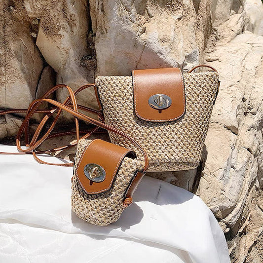 Front view of Two mini PU mix raffia straw bucket crossbody bags, one large and one small.