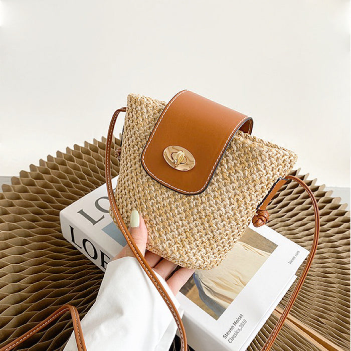 Model holding a middle size of Mini raffia straw bucket crossbody bag, showcasing the texture detail.