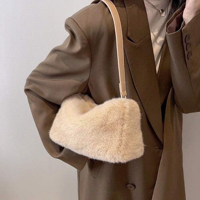 Model carrying a beige mini fluffy shearling baguette bag on the shoulder, easy for commuting and weekends.