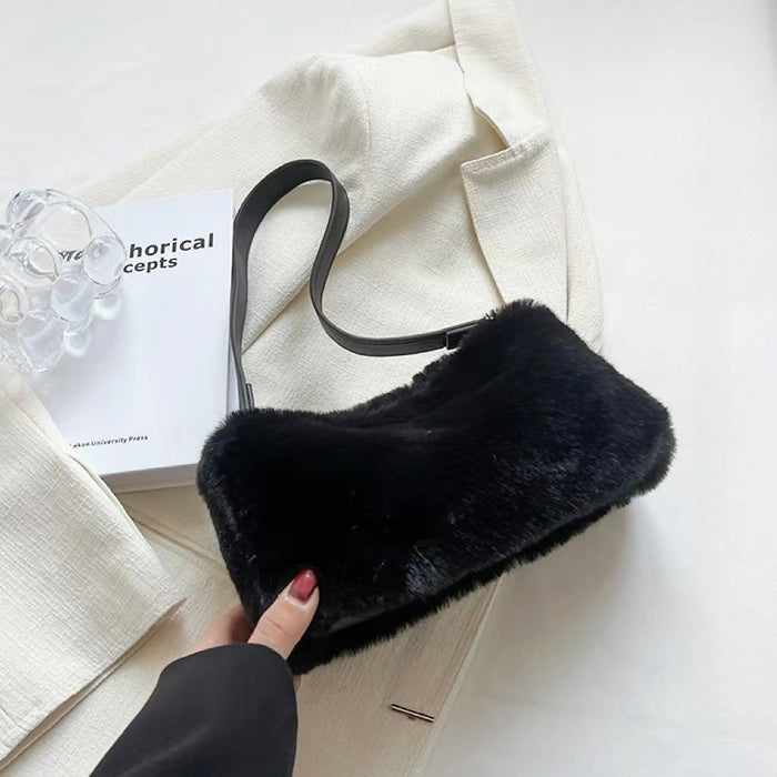 Close-up of Black mini shearling baguette bag with a shoulder strap and zip-top fastening shoulder bag.