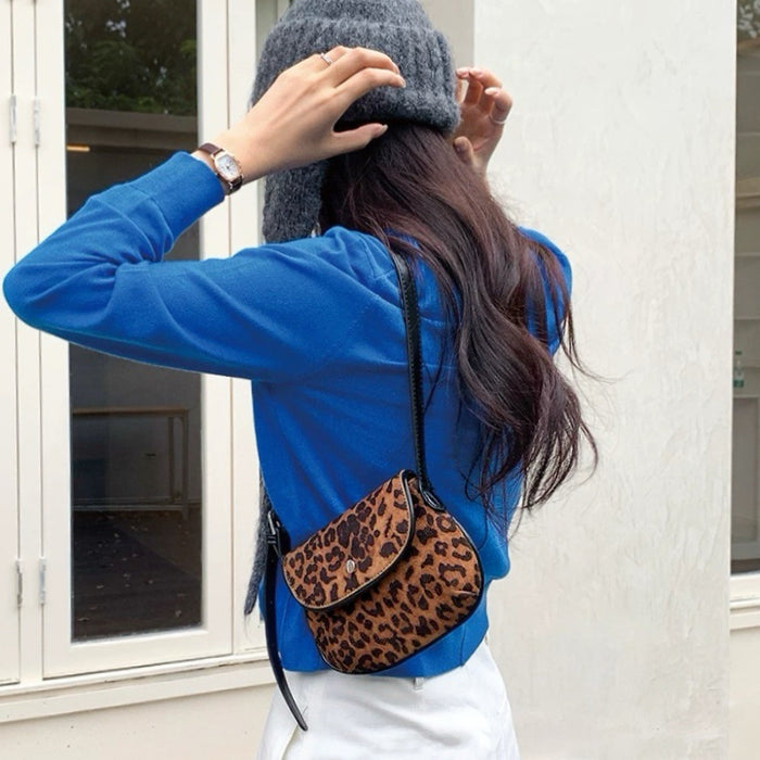 Model carrying the leopard print saddle bag over the shoulder for an urban look.