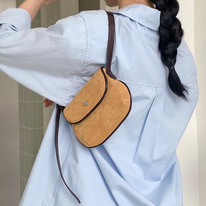 Model carrying the khaki suede saddle bag on her shoulder for an urban look.