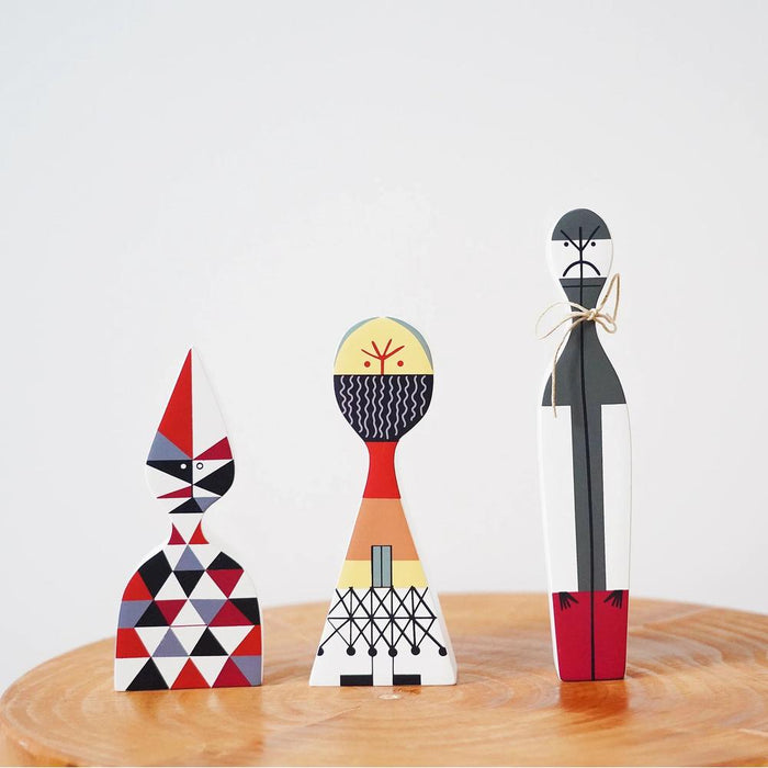 Set of three abstract wooden figurines with geometric patterns on a wooden surface.