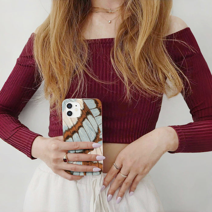 Held by a person, Morpho Flair acrylic case with shimmering butterfly wing motifs. Elegant artistic style.