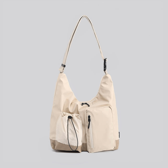 Large khaki nylon crossbody bag with multiple front pockets, including a drawstring and zipper compartment.