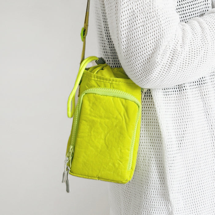 A woman styling a neon yellow bottle bag for a spring City Walk
