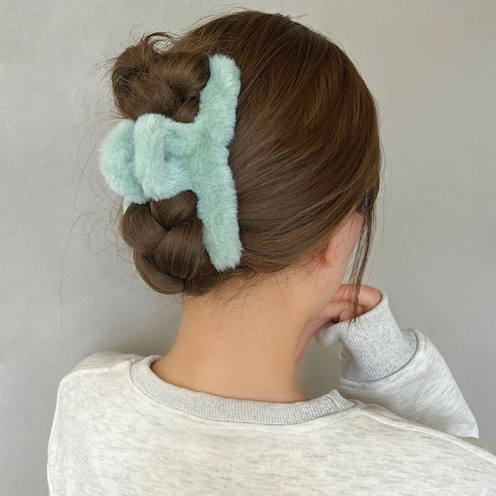 Model wearing a green Plush Hair Claw, great for everyday styling and gifting.