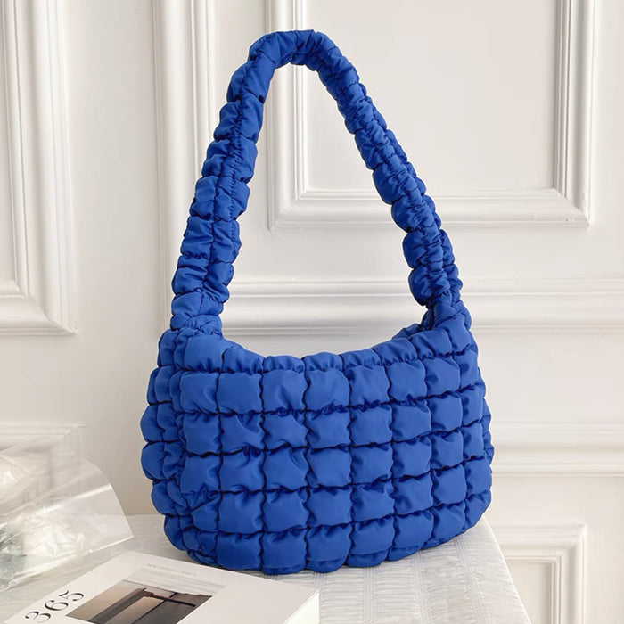 Vibrant blue puffy shoulder bag with a quilted texture.