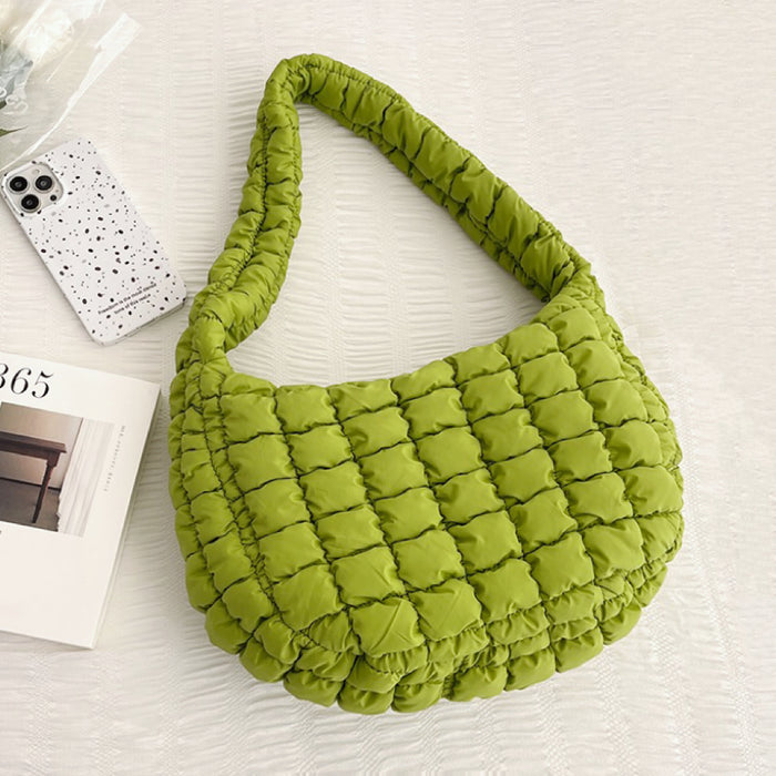 Close-up of the high-quality quilted stitching on the light green puffy bag.