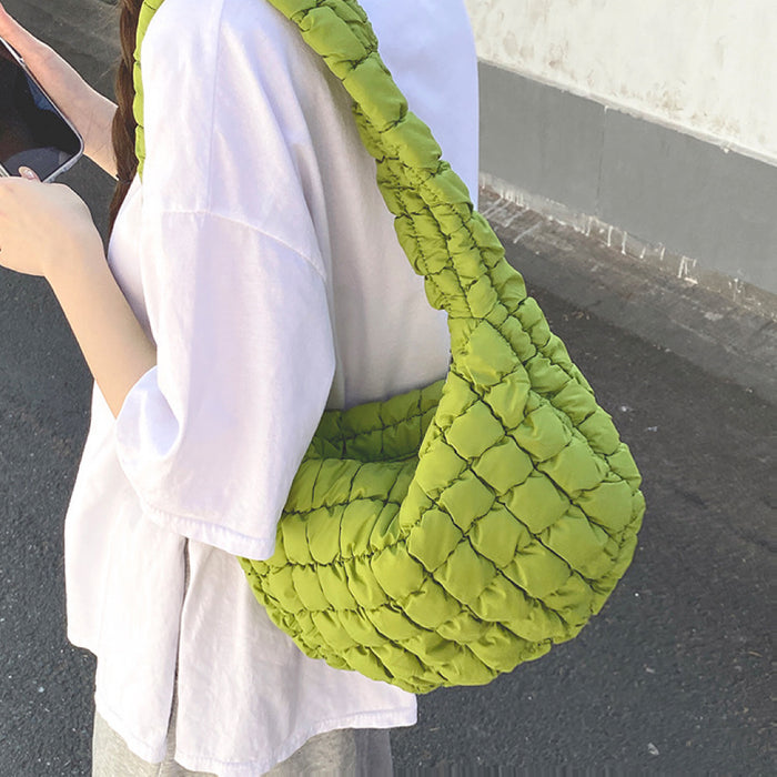 Model wearing the light green puffy bag on her shoulder showcasing the soft silhouette.