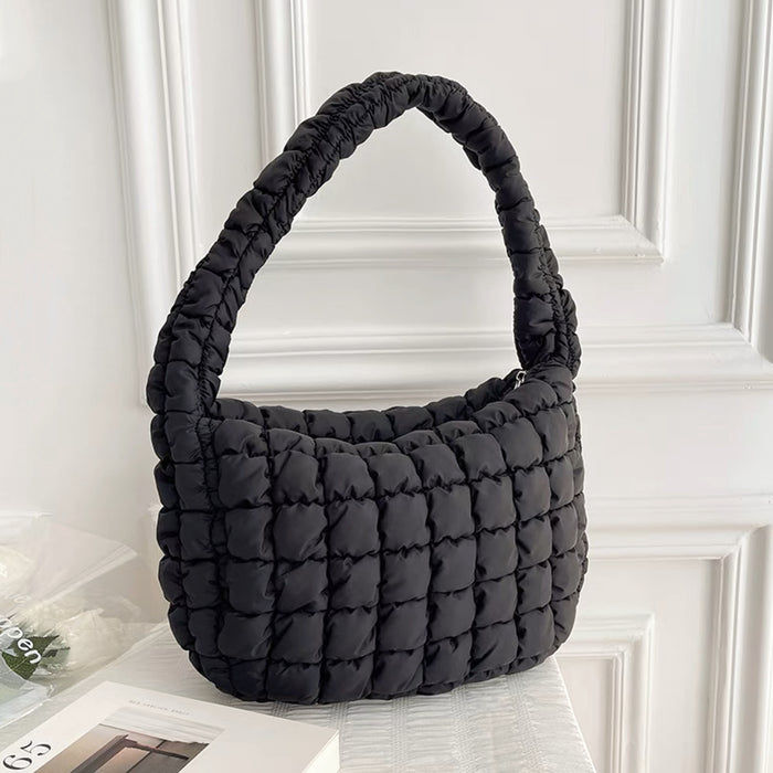 Front view of classic black puffy shoulder bag on a white background.