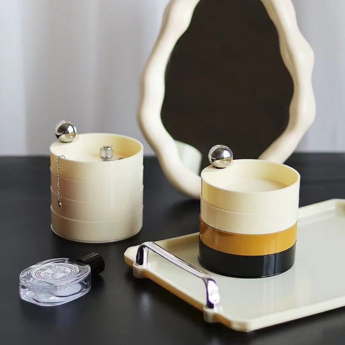 Front view of Cream and black multilayer makeup storage boxes with silver accents.