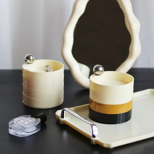 Front view of Cream and black multilayer makeup storage boxes with silver accents.