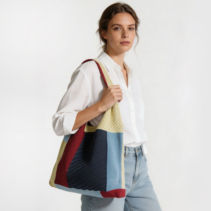 Model styling the red and navy blue crochet knit tote bag on her shoulder.