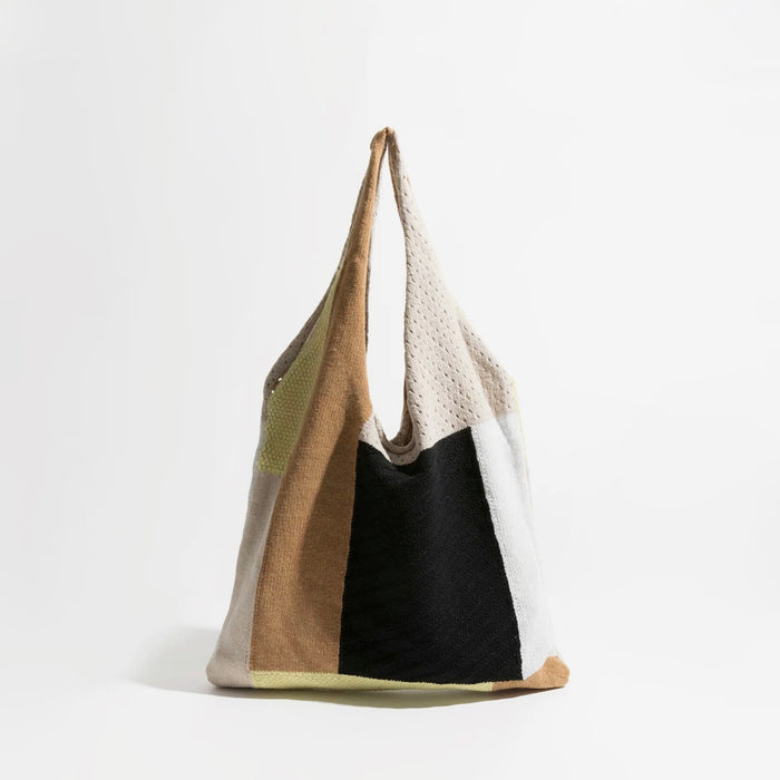 Front view of the earthy neutral colorway crochet tote bag with beige, warm brown, and black knit panels.