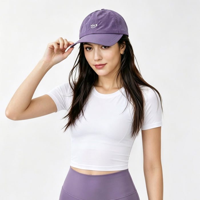 Model wearing the purple quick dry running cap to add a pop of color to sports styling.