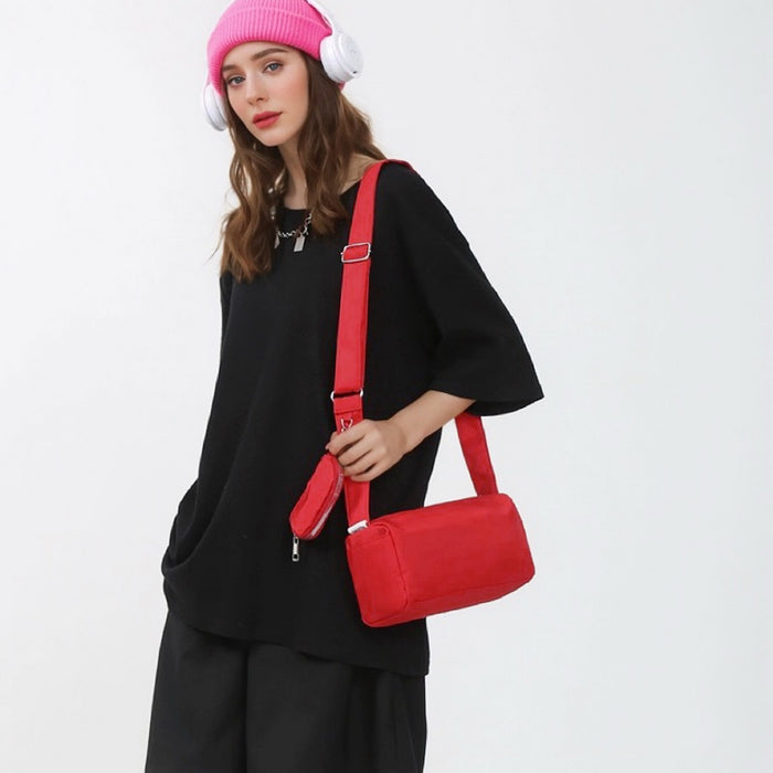 Model carrying a red nylon crossbody bag on her shoulder, ideal for city walks and gifting.
