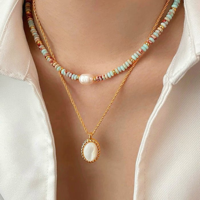 Model wearing two necklaces as layer style, one is aqua beads necklace and one is gold jade.