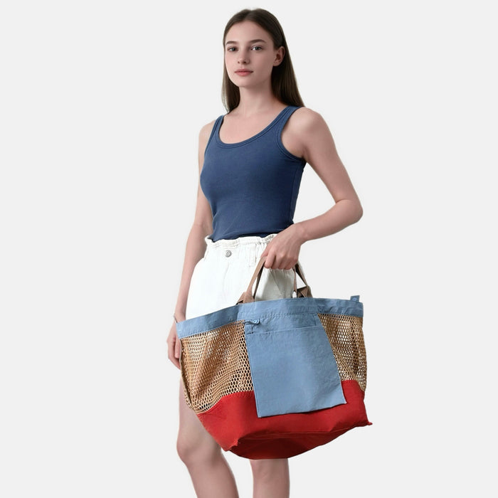 Model holding the reversible nylon tote bag showing the blue and red color contrast.