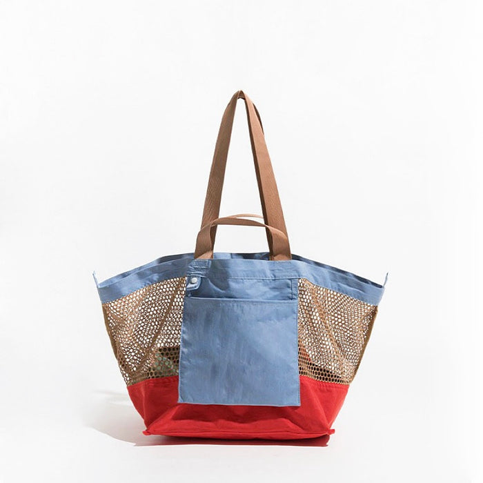 Front view of the blue and red double-sided tote bag featuring a front slip pocket.