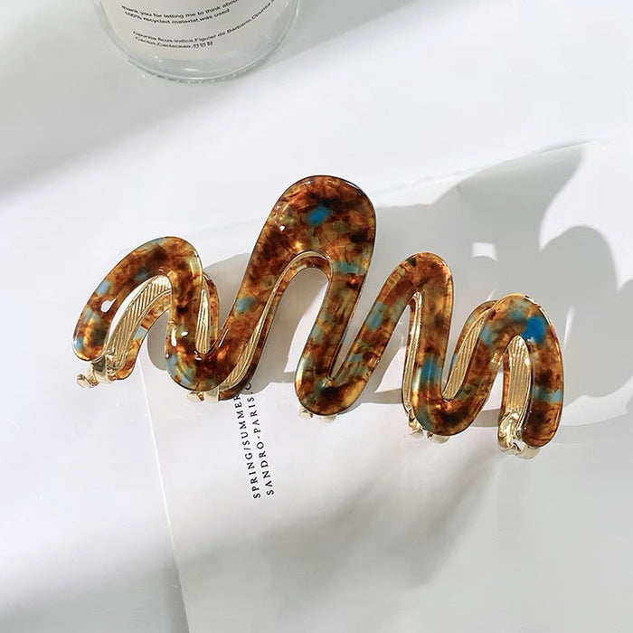 Angled view of Painted Wave Hair Claw  in brown, ideal for quick updos and ponytails.