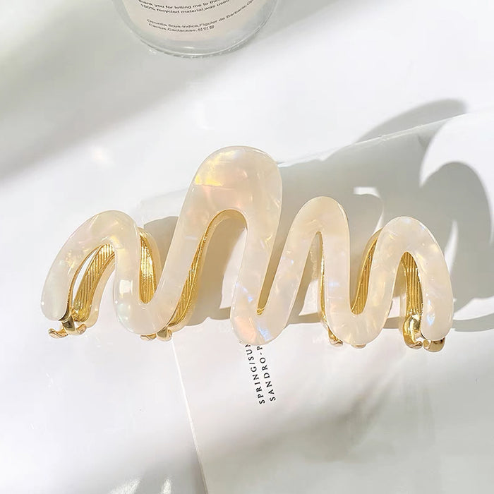 Flat lay of Painted Wave Hair Claw in white, great for everyday styling and gifting.