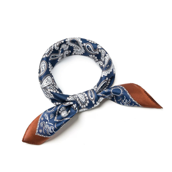 Detail view of luxurious silk-blend scarf tied in stylish knot featuring classic blue paisley print for professional attire.