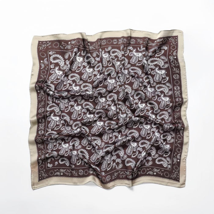 Close-up of brown paisley scarf highlighting refined edge detailing and artistic craftsmanship.