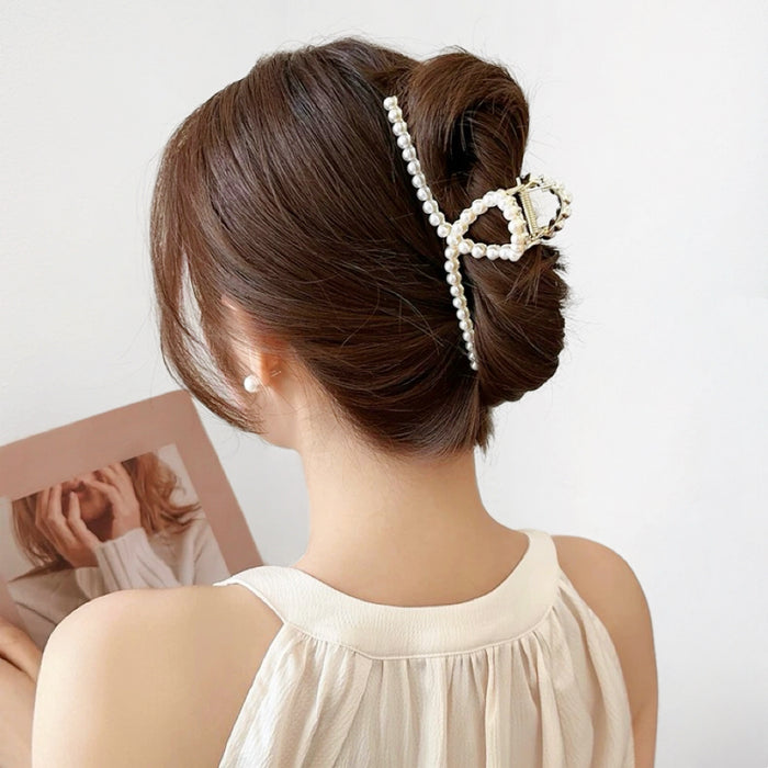 Model wearing a large pearl hair claw in a low bun; elegant hair accessory for long thick hair.