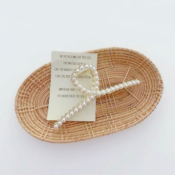 Close-up of the cross-over metal design with pearls; showing the reinforced alloy architecture.