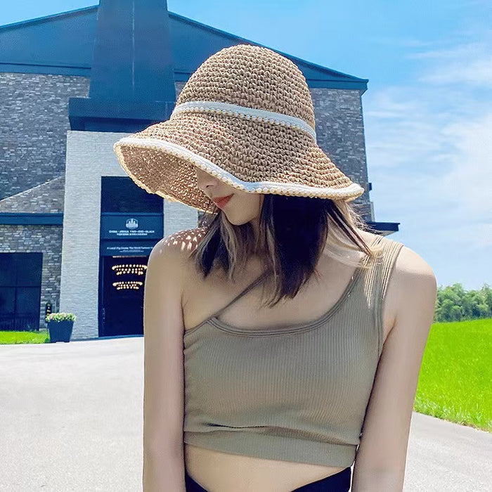 Model wearing breathable straw sun hat with pearl accent providing stylish shade for poolside relaxation and picnics.