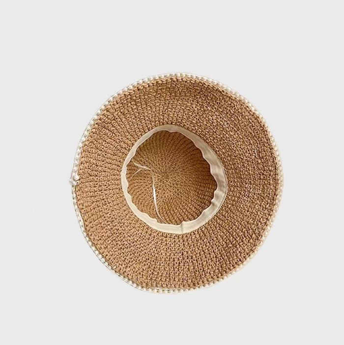 A top-down view of a woven straw hat, showcasing  interior lining and drawstring for size adjustment.
