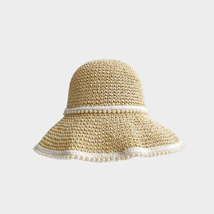 Close-up of light beige sun hat highlighting delicate woven straw pattern for tropical summer styling.