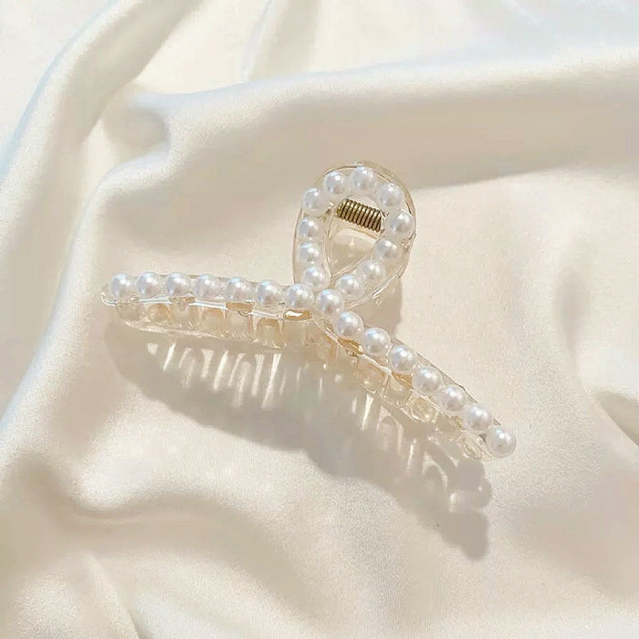 Detailed view of the cross-over design pearl hair clip; showcasing the premium architecture.