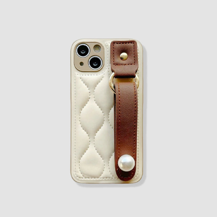 Cream quilted PU leather iPhone case with a brown wristband and pearl accent.