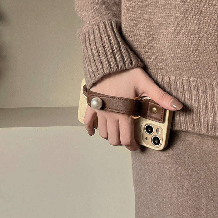 Model holding Pearl Wristband Case. Sophisticated pearl-beaded wristlet on a premium silicone body.