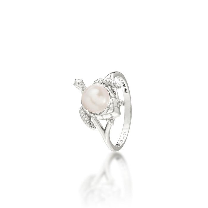 A sterling silver ring featuring a central white freshwater pearl set on a Hawaiian green sea turtle's back, on a white background with a soft reflection.