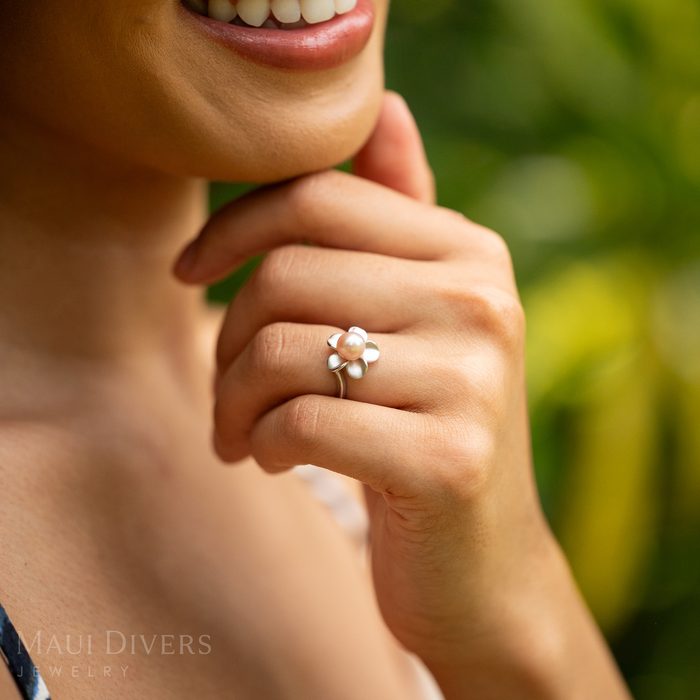 13mm Pick A Pearl Plumeria Ring in Sterling Silver with a Pink Pearl on a woman with a blurred green background