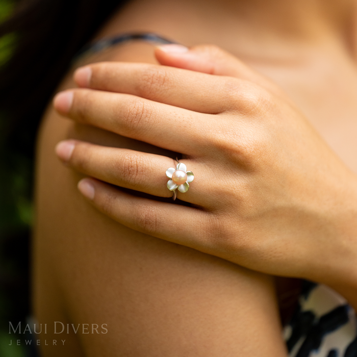 Close up of a 13mm Pick A Pearl Plumeria Ring in Sterling Silver with a Pink Pearl on a woman's hand