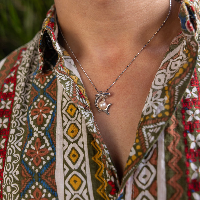 23mm Pick A Pearl Shark Pendant in Sterling Silver with a Peach Pearl on a person's neck with a colorful patter shirt