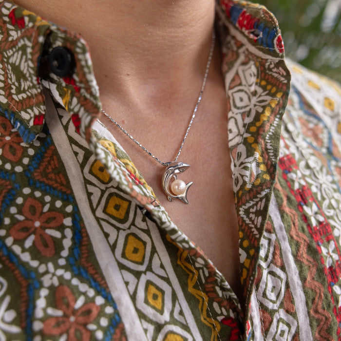 23mm Pick A Pearl Shark Pendant in Sterling Silver with a Peach Pearl on a person's neck with a colorful patter shirt