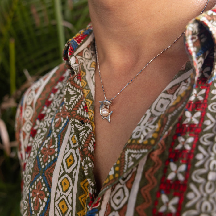 23mm Pick A Pearl Shark Pendant in Sterling Silver with a Peach Pearl on a person's neck with a colorful patter shirt